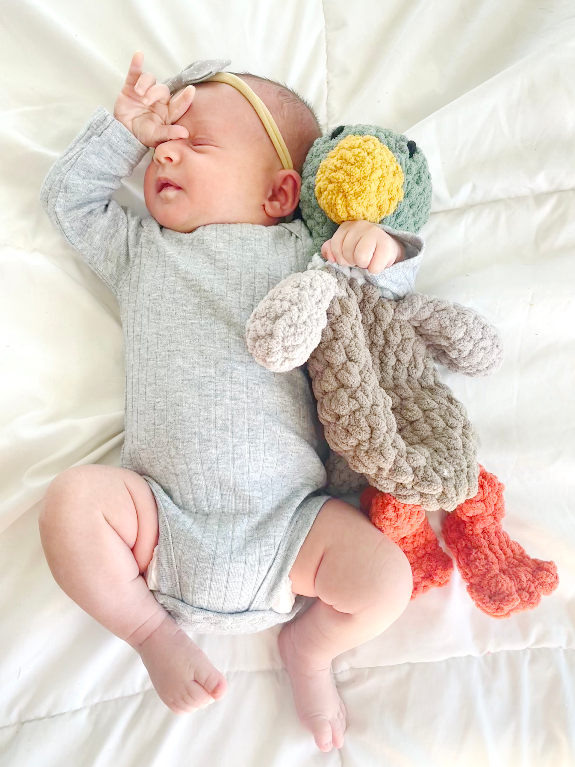 Baby cuddling crochet duck